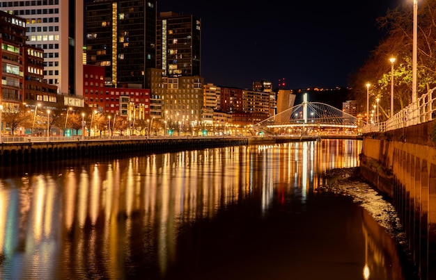 Cityscape of modern building in the night near the river and bridge Modern architecture building