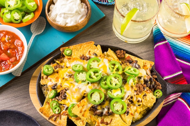 Photo classic nachos with ground beef and fresh jalapeno chili peppers.