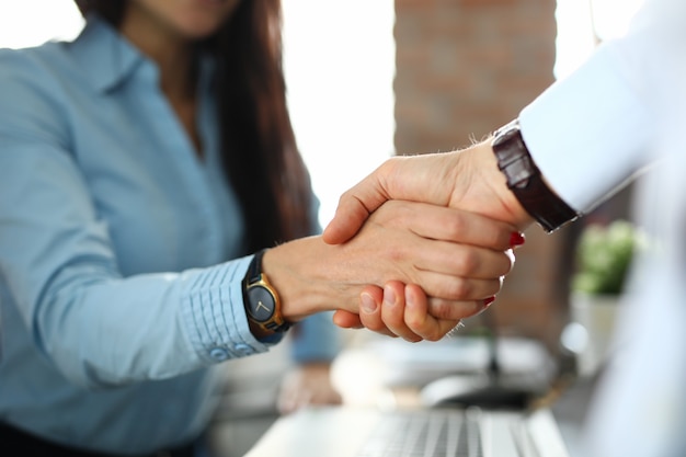 Client shaking hands with insurance agent in office closeup