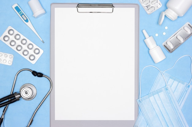 Clipboard with blank paper, stethoscope, thermometer, medicines. Medical concept