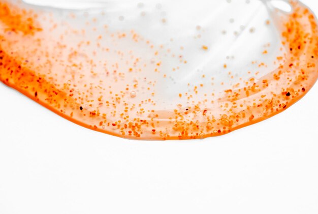 A close up of a clear glass with orange and red powder on it.