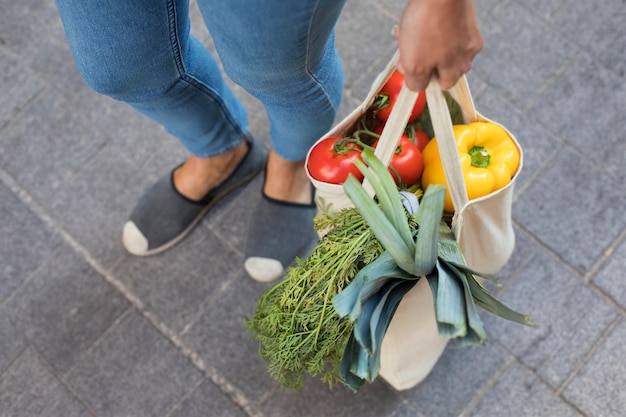 Close up hand holding bag with vegetables