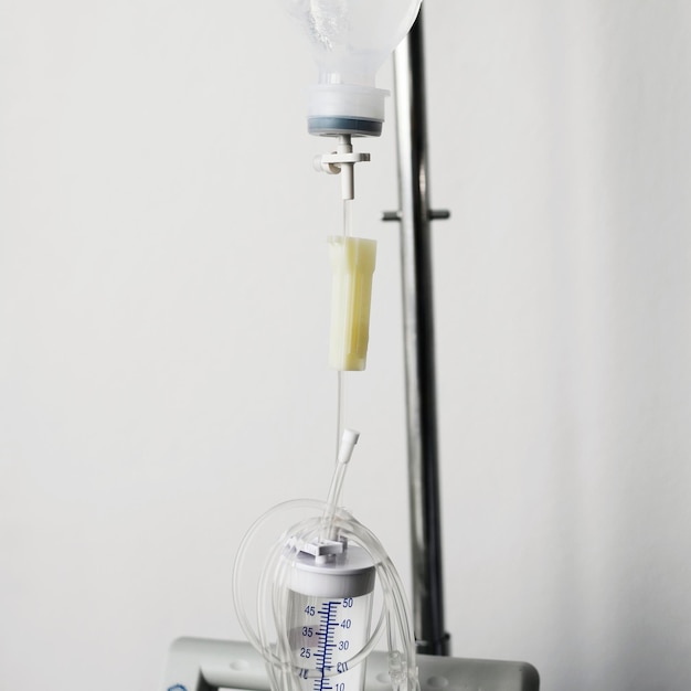 Photo close-up of iv drip hanging against wall in hospital