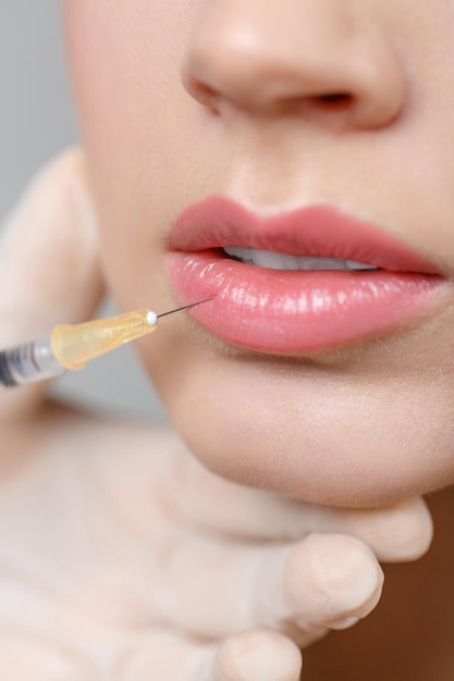 Close-up portrait of woman getting cosmetic lifting injection in lips. Plastic Surgery. Cosmetic Treatment