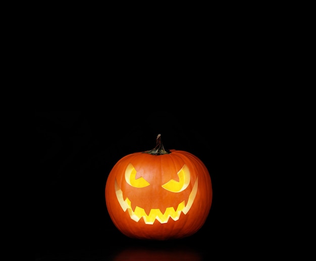 Close up view of scary Halloween pumpkin with eyes glowing inside