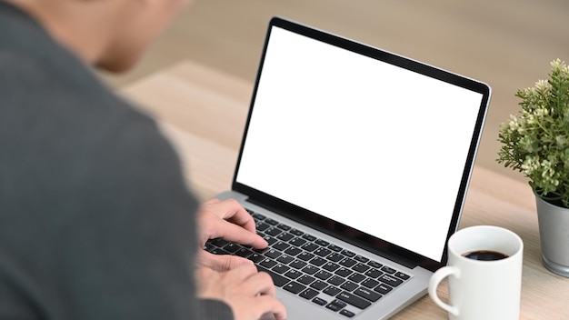 Close up view of young man using computer laptop in living room.