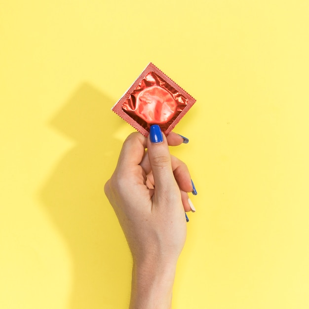 Photo close-up woman holding up a condom