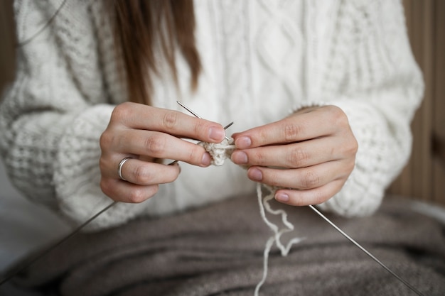 Close up woman knitting at home