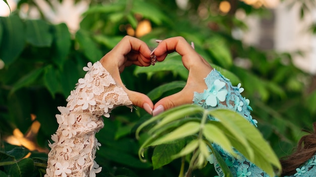 Foto primo piano delle mani delle donne che mostrano a forma di cuore