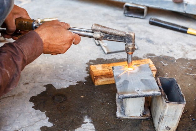 Close up worker do metal cutting with acetylene torch