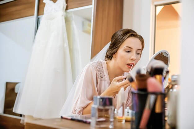 Photo close-up of young woman applying make-up at home