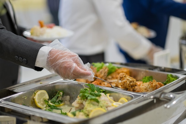 Foto guanti da indossare a mano in primo piano che raccolgono cibo catering l'ora della cena prevenire la malattia di coronavirus covid 19xaxa