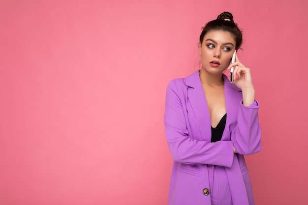 Closeup photo of upset dissatisfied beautiful young woman wearing purple suit talking on the mobile