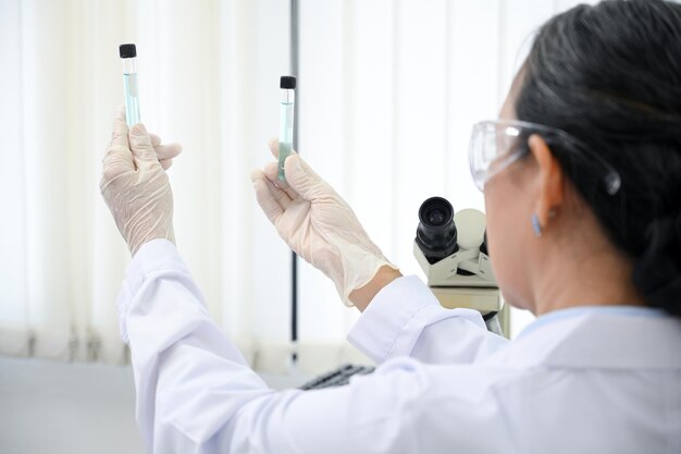 Photo closeup specialist senior scientist holding a test tubes working in the laboratory