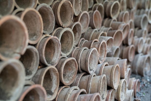 Closeup of stacks of old used weathered terra cotta flower pots in gardening shed