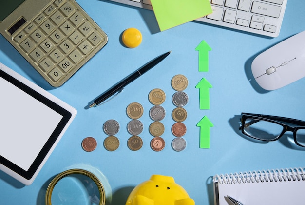 Coins growth arrow and business objects on the blue background Business Finance