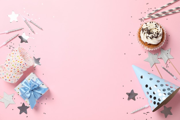 Photo composition with cupcake and birthday accessories on pink background, space for text