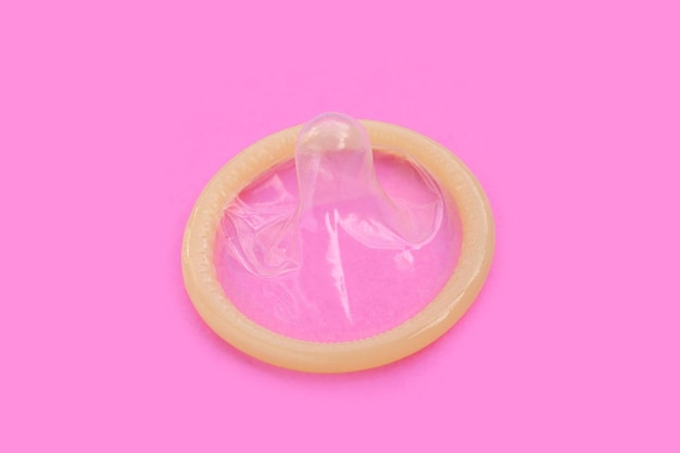 Photo condom on pink background copy space