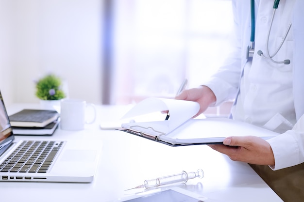 Consult medical, Close up doctor reading a report on workplace.