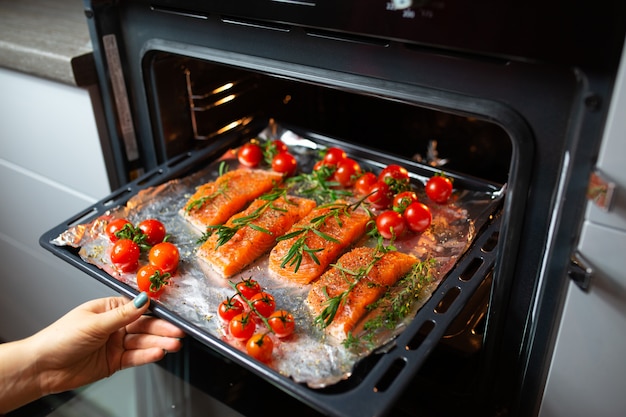 Cooking salmon in the oven. Housewife is preparing dinner. chef is cooking red fish. Cooking fish in the oven.