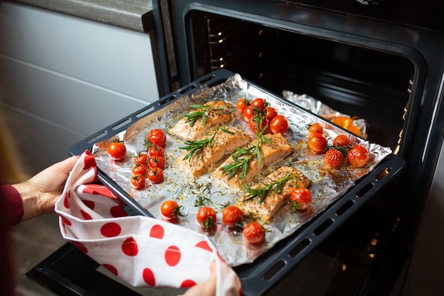 Cooking salmon in the oven. Housewife is preparing dinner. chef is cooking red fish. Cooking fish in the oven.