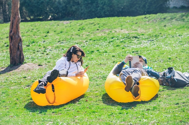 Photo couple laying in city park on yellow inflatable mattress