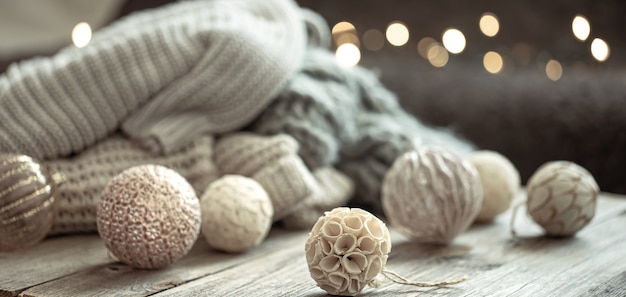 Cozy Christmas background with Christmas decorations and knitted element on a blurred background.