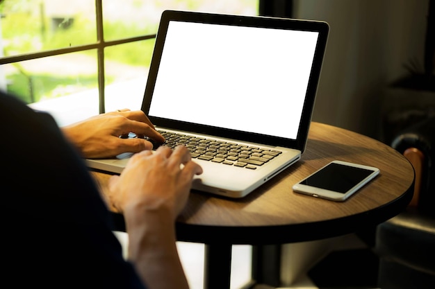 Cropped hands using laptop at table