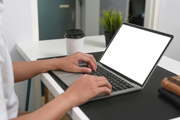 Cropped shot of man hands typing on laptop computer at his office desk.