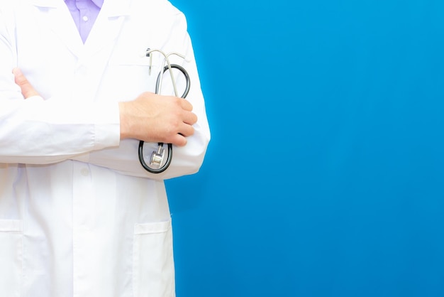 Foto vista ritagliata di un uomo medico in uniforme in piedi e con uno stetoscopio in mano copia lo spazio per il tuo testo