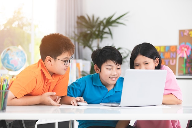 Photo cute asian children using laptop together.