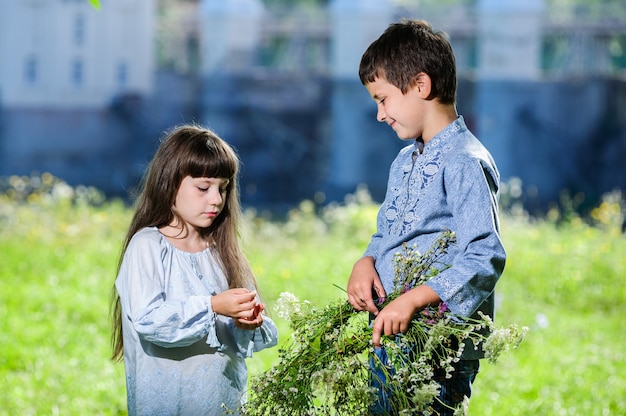 Cute boy and girl, brother and sister, in traditional Ukrainian embroidered clothes.