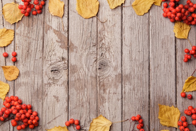 De herfstsamenstelling met mooie gele bladeren op houten achtergrond. Bovenaanzicht, plat lag, vintage toning. Herfst ontspannen concept