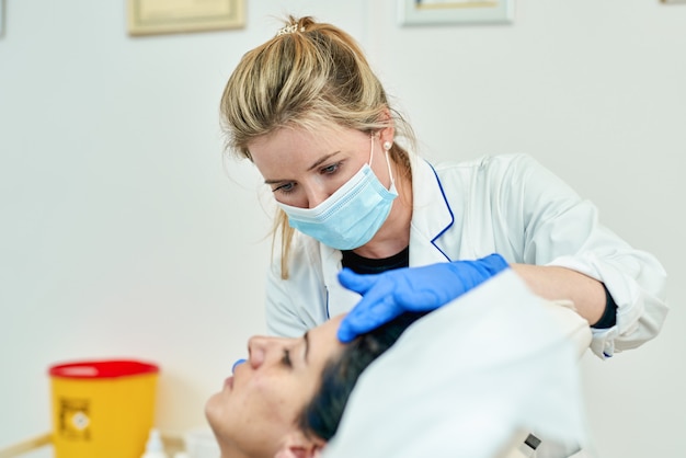 Delicate scrupulous plastic surgeon performing lip augmentation