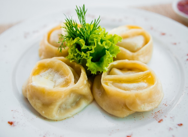 Dish out the dough on lettuce leaves on a white plate. Restaurant.