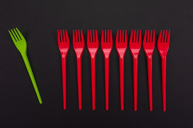 Disposable red and green plastic forks isolated on background