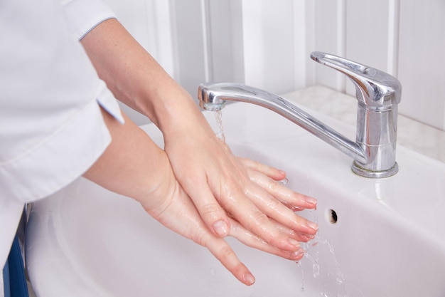 The doctor washes his hands under the tap before the operation