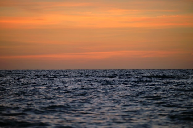 Dramatic red ocean waves at sunset with soft evening sea dark water