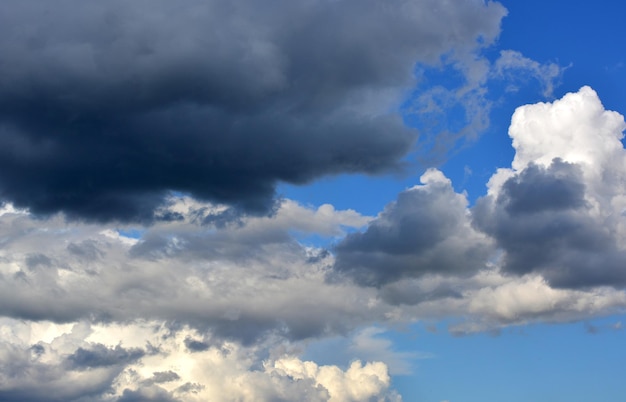 Foto cielo drammatico con nuvole scure di pioggia sullo sfondo del cielo blu