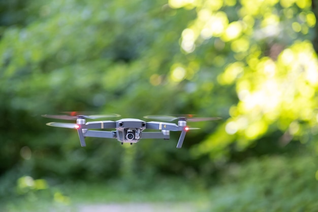 Drone aircraft with blurred fast rotating propellers and photo camera flying in air.