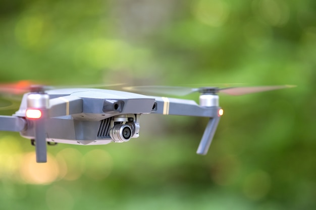 Drone aircraft with blurred fast rotating propellers and photo camera flying in air