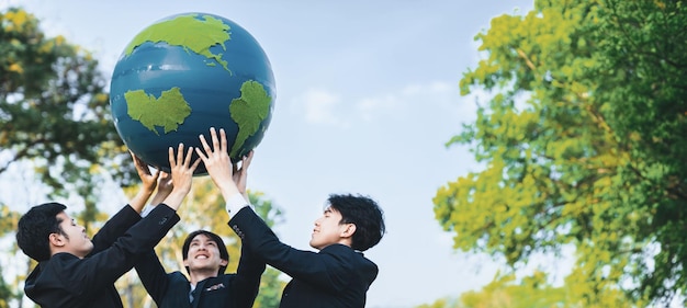 Photo earth day concept with big earth globe held by group of asian business people team promoting environmental awareness with environmentally sustainability and esg principle for brighter future gyre