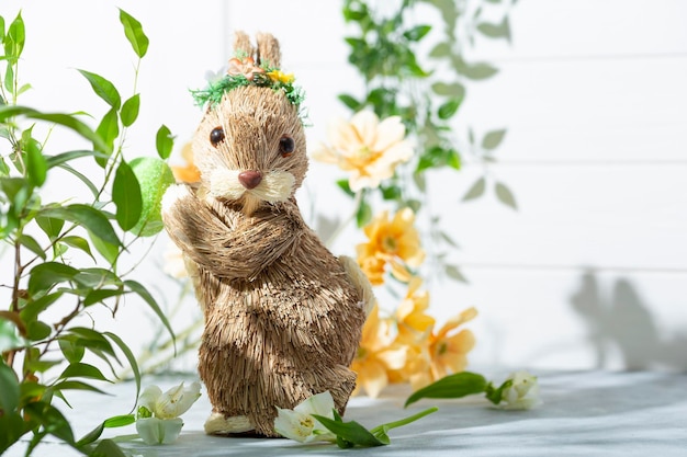 Easter bunny colored eggs and spring flowers on the white background festive easter card with free