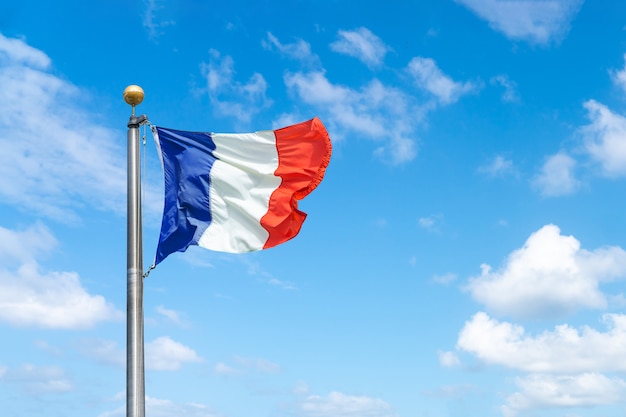 Foto een franse vlag tegen een blauwe hemelachtergrond