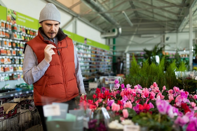 Een man in een bloemenwinkel kiest een boeket voor zijn geliefde