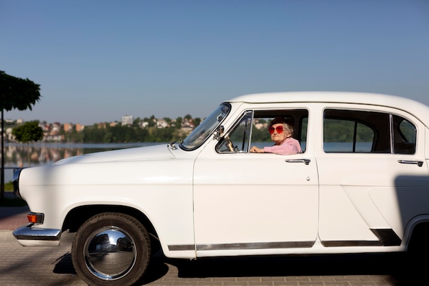 Elderly woman traveling with her white car