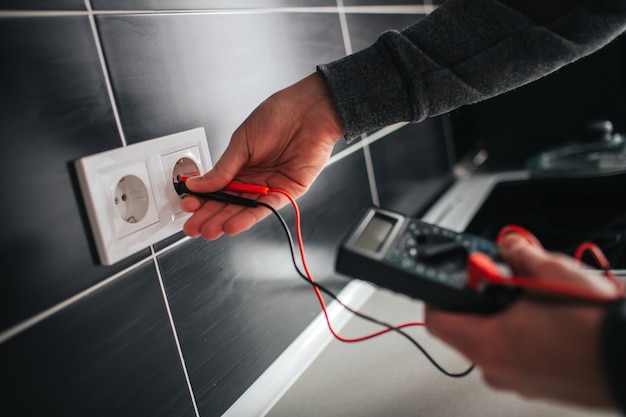 Electrician, Electrician installing new current socket with screwdriver. Installing electrical outlet or socket - closeup on electrician hands.