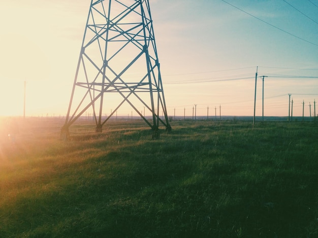 Photo electricity pylon on field against sky during sunset