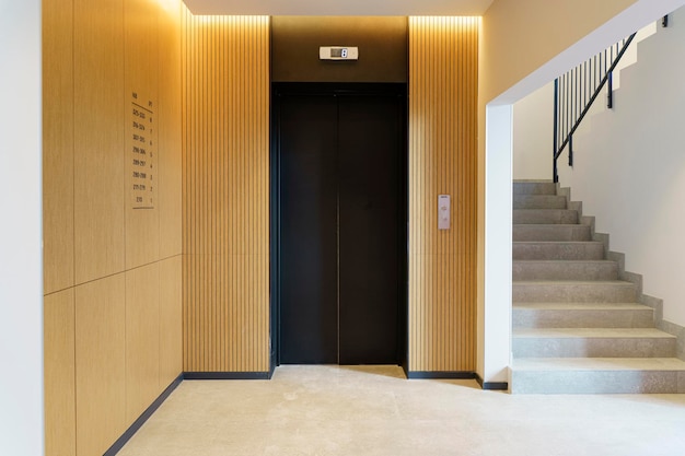 Photo elevator in the lobby hall of an apartment building modern decor and wood finishing of the ground fl...