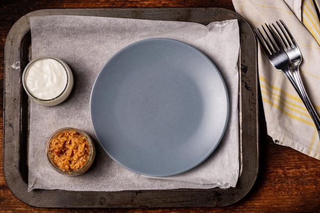 Photo an empty gray plate and ketchup with mayonnaise next to it preparing for serving